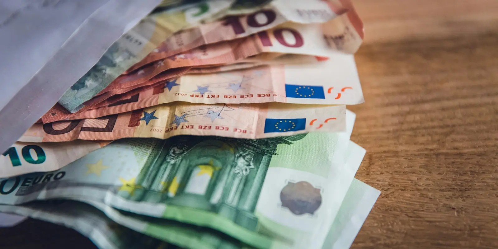 sueldo auxiliar administrativo estado 2026 Billetes de euro sobre una mesa de madera